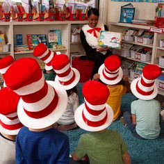 a woman reading to children wearing cat in the hat hats