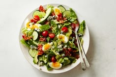 a salad with cucumbers, tomatoes and eggs