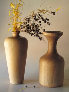 two wooden vases with flowers in them on a table