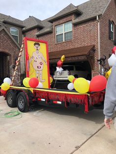 a man standing in front of a truck with balloons on it's flatbed