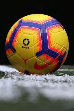 a yellow and blue soccer ball sitting on the ground