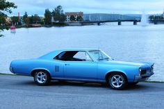 a blue car parked next to a body of water