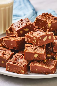 a white plate topped with chocolate fudge brownies next to a glass of milk