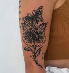 a woman's arm with a butterfly and flower tattoo on the left side of her arm