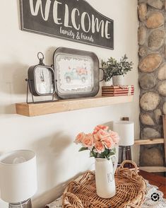 a welcome sign above a wicker basket with flowers on it and a clock in the background