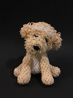 a crocheted teddy bear sitting on a black surface