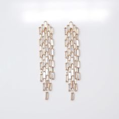 two pairs of gold toned earrings on a white background