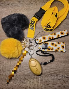 the contents of a purse laid out on a wooden table with yellow and black accessories