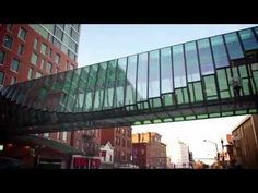 a glass bridge over a city street next to tall buildings