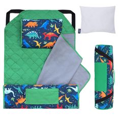 a green and blue quilted baby bedding set with dinosaurs on it, next to a white pillow