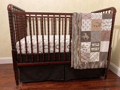 a crib with a quilt on the top and bottom rail, next to a hardwood floor