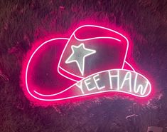 a neon sign that says yeehah with a cowboy hat on the front and side