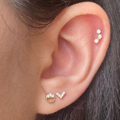 a close up of a person's ear with two small white stones on it