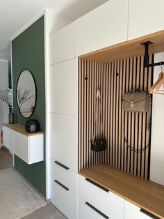 an empty room with white cabinets and green accenting the walls, along with a mirror on the wall