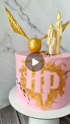 a pink cake with gold decorations on top