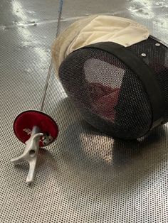 a piece of luggage sitting on top of a floor next to a red wheel with a handle