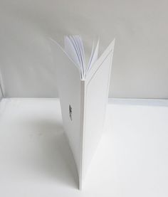 an open book sitting on top of a white table