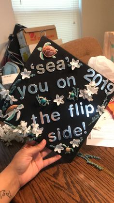 someone is holding up a graduation cap that says, sea you on the flip side