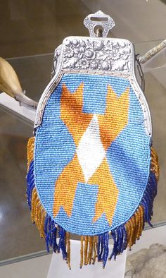 a blue and yellow purse with gold stars on it's side hanging from a hook