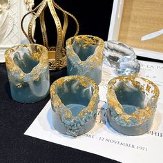 four blue and gold vases sitting on top of a table next to a crown