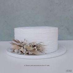 there is a white cake with feathers on it