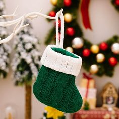 a christmas ornament hanging from a tree in front of a holiday wreath and other decorations