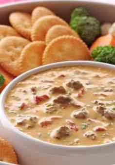 a white bowl filled with soup next to crackers and broccoli