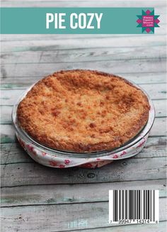 a pie sitting on top of a wooden table next to a magazine title that reads pie cozy