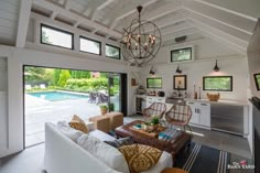 a living room filled with furniture next to a swimming pool