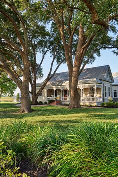 a white house surrounded by trees and grass