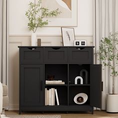 a living room with a black cabinet and bookshelf in front of the window