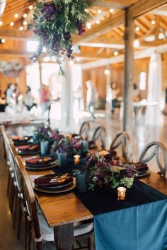 Wood table with navy velvet runner, gold chargers, black plates and burgundy velvet napkins. Tablescape Holiday, Velvet Runner, Holiday Event Decor, Event Decor Ideas, Winter Dinner Party, Corporate Dinner, Corporate Holiday Party, Thanksgiving Dinner Party, Party Tablescapes