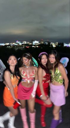 four girls dressed up in costumes posing for the camera