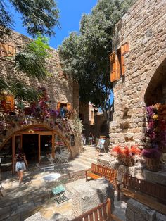 an outdoor area with benches, tables and potted plants on the side of it