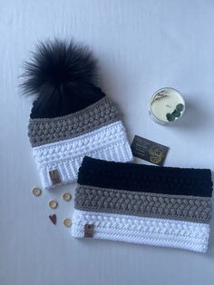 two crocheted hats with black pom - pom on top