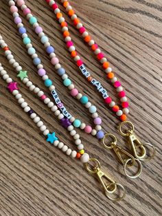 four different colored beaded bracelets on a wooden table