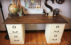 an office desk with two drawers and a globe on top