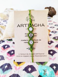 the bracelet is made out of beads and has a name tag on it that says arttacha