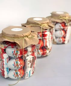 four jars filled with candy sitting on top of a table