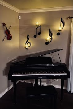 a black piano sitting in front of a wall with musical notes hanging on it's side