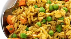 a bowl filled with rice, peas and carrots