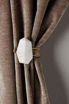 a close up of a curtain with a white hexagonal object attached to it