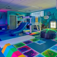 the children's playroom is brightly lit with blue and pink lighting, including an inflatable slide