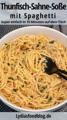 a white bowl filled with pasta and topped with parsley