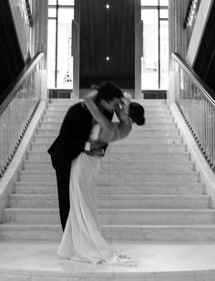 a bride and groom kissing on the stairs