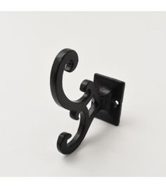 a black metal hook on a white background with the letter c in it's center