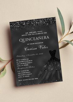 a black and white wedding card with an elegant dress on it, surrounded by greenery