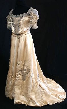 Haute couture Edwardian fashion French ball gown dress from 1900 forgotten House of Dumay. Made in cream silk satin, tulle with chiffon ruffle and beaded faux pearls, rhinestones, and emeralds on the neckline and bodice. Flounces matching lace decorate the sleeves and skirt with satin rose, leaves and stems hand embroidered silk floss jewel creation and a bow on the back. The lady who wore this gown must have felt like a princess. #hautecouture #couture #vintage #edwardian #gown #dress #fashion 1909 Fashion, Period Outfit, Vintage Couture, Julia Roberts, Edwardian Fashion