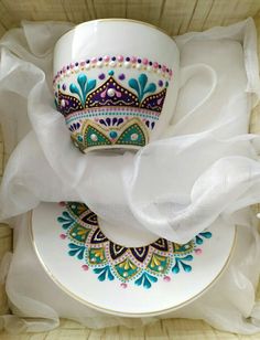 a white cup and saucer sitting on top of a plate in a wooden box