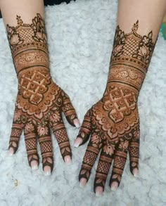 two hands with henna designs on them